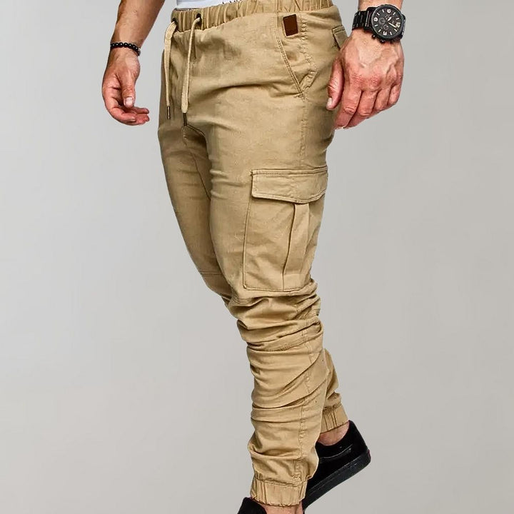 Khaki cargobroek voor heren met elastische tailleband, zijzakken en trekkoord. Ideaal voor casual en outdoor activiteiten. Comfortabele pasvorm.