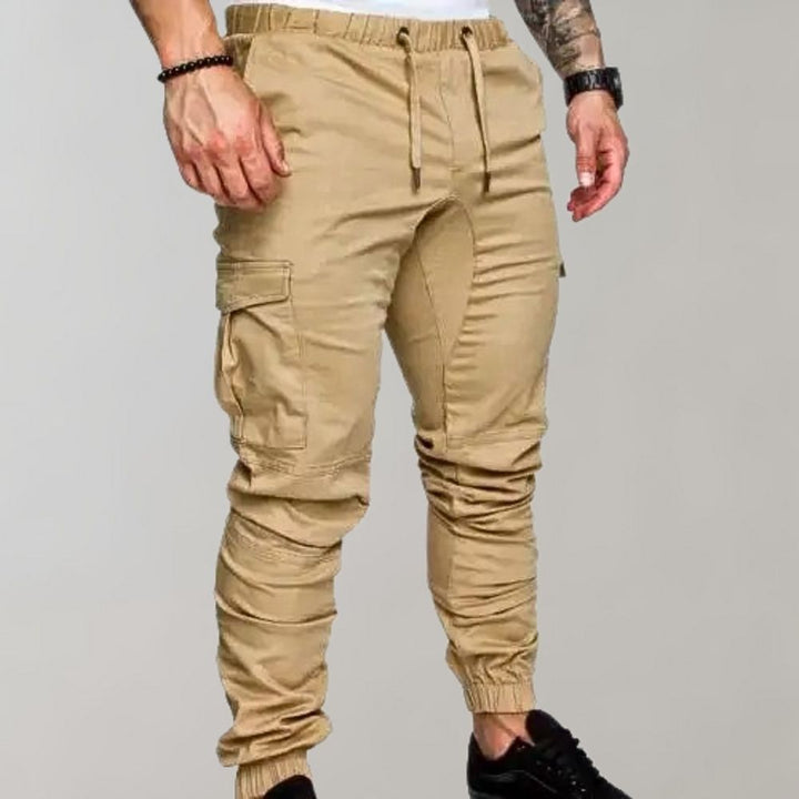 Khaki cargo joggingbroek voor heren met elastische tailleband, trekkoord en zijzakken. Comfortabele streetwear-stijl, ideaal voor casual outfits.