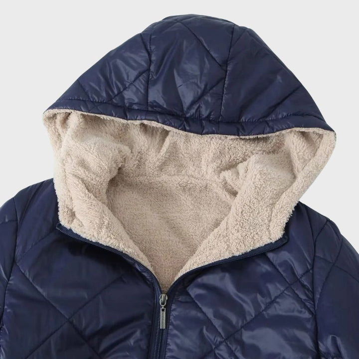 Donkerblauwe gewatteerde jas met capuchon, gevoerd met beige fleece. Winterjas, warme kleding, modieuze damesjas, comfortabele buitenkleding.