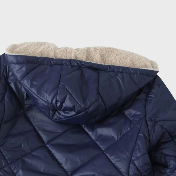 Donkerblauwe gewatteerde jas met capuchon, gevoerd met beige fleece. Ideaal voor wintermode, biedt warmte en stijl. Perfect voor koude dagen.