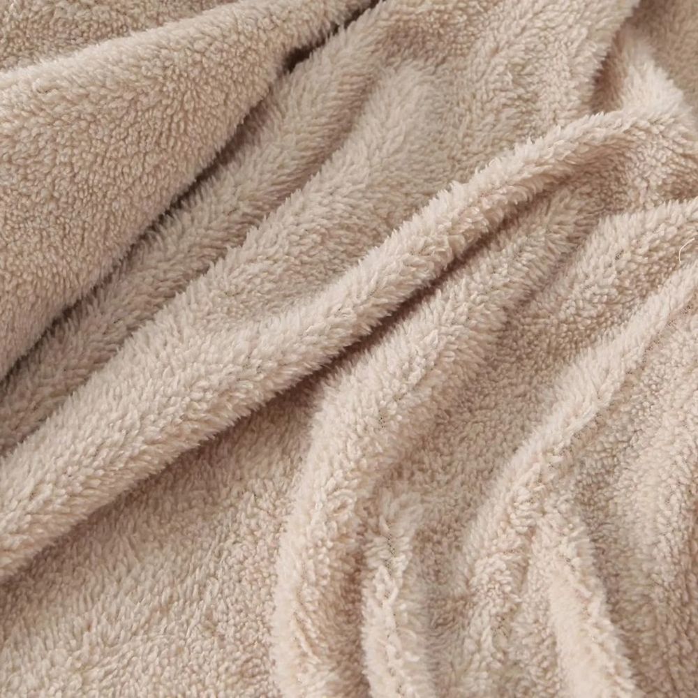 Beige fleece stof close-up, zachte textuur, ideaal voor warme kleding en dekens. Hoogwaardige kwaliteit, comfortabel en duurzaam materiaal.