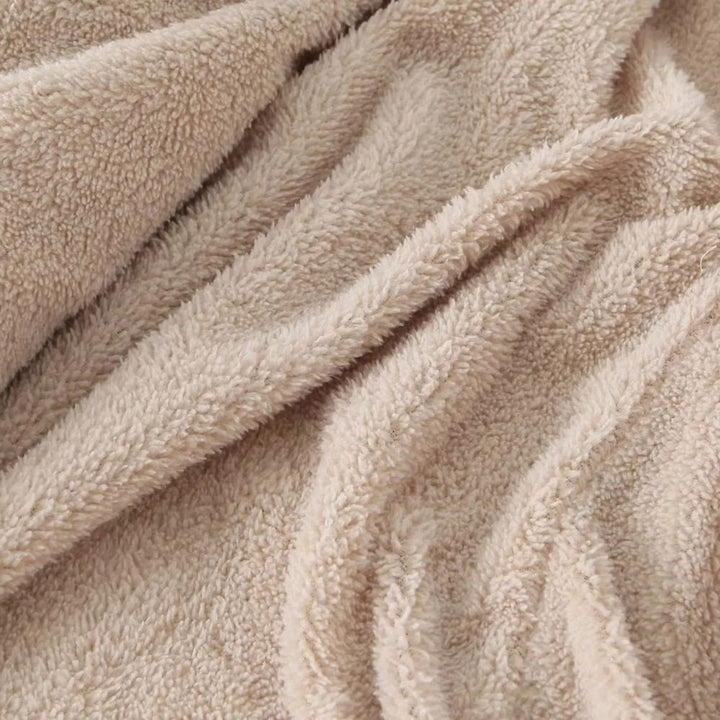 Beige fleece stof close-up, zachte textuur, ideaal voor warme kleding en dekens. Hoogwaardige kwaliteit, comfortabel en duurzaam materiaal.