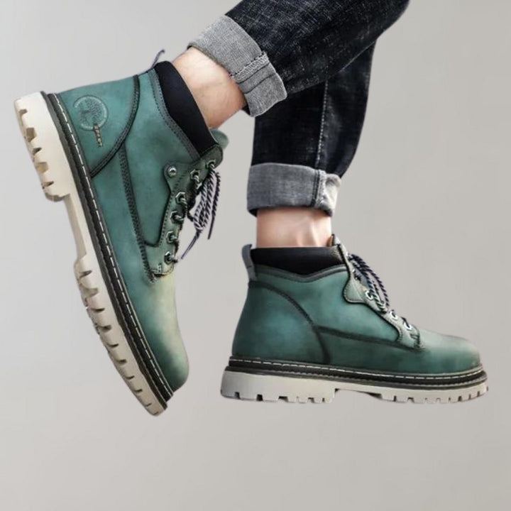 Groene leren wandelschoenen met dikke zolen en veters, gedragen door een persoon met opgerolde jeans. Comfortabele en duurzame outdoor schoenen.