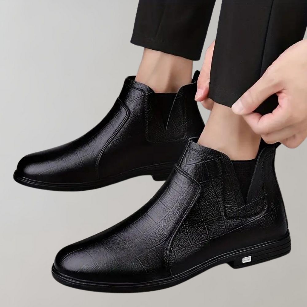 Zwarte leren Chelsea boots voor heren, stijlvolle enkellaarzen met elastische zijkanten, geschikt voor formele en casual outfits.