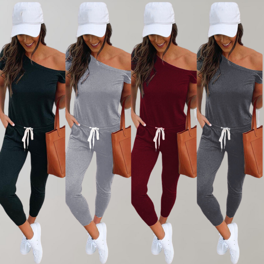 Vrouw in off-shoulder jumpsuit, verkrijgbaar in zwart, grijs, rood, met witte pet en sneakers. Modieuze dameskleding, casual stijl.