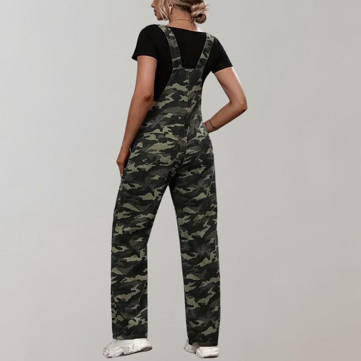 Vrouw in camouflage tuinbroek, zwarte top en witte sneakers, rugaanzicht. Modieuze dameskleding, casual stijl, urban mode.