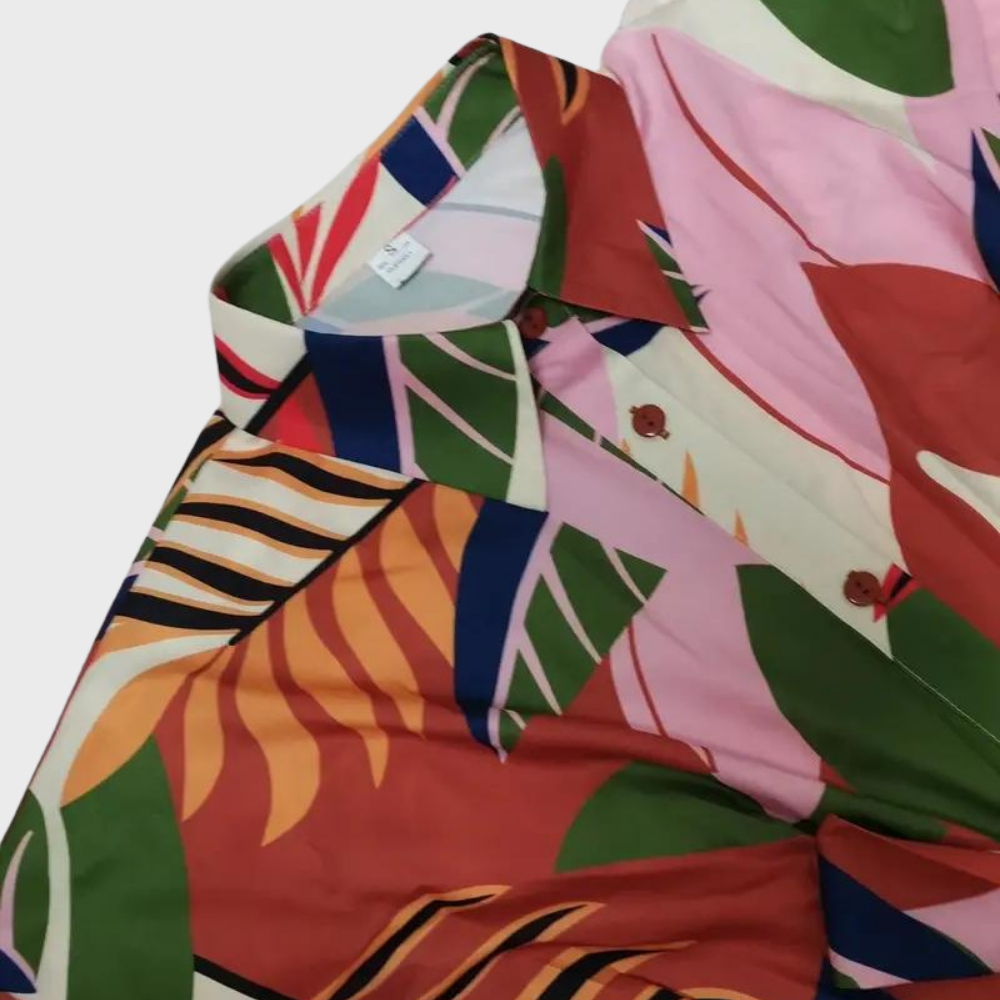 Kleurrijk damesoverhemd met tropische print, roze en groene bladeren, knoopsluiting. Perfect voor zomerse mode en casual outfits.
