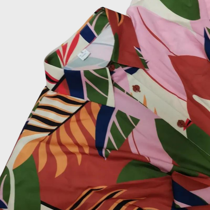 Kleurrijk damesoverhemd met tropische print, roze en groene bladeren, knoopsluiting. Perfect voor zomerse mode en casual outfits.