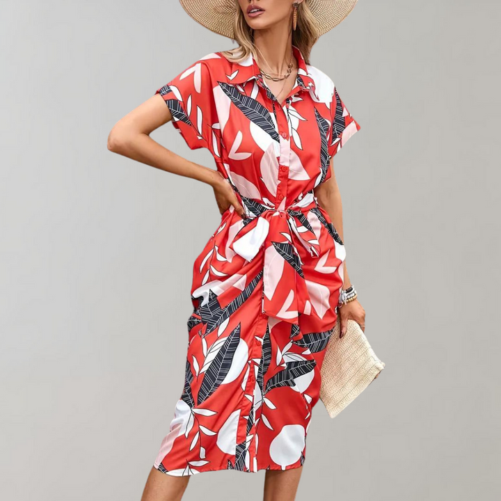 Rode zomerjurk met tropisch bladpatroon, korte mouwen en strikceintuur. Perfect voor damesmode, strandkleding en casual zomeroutfits.