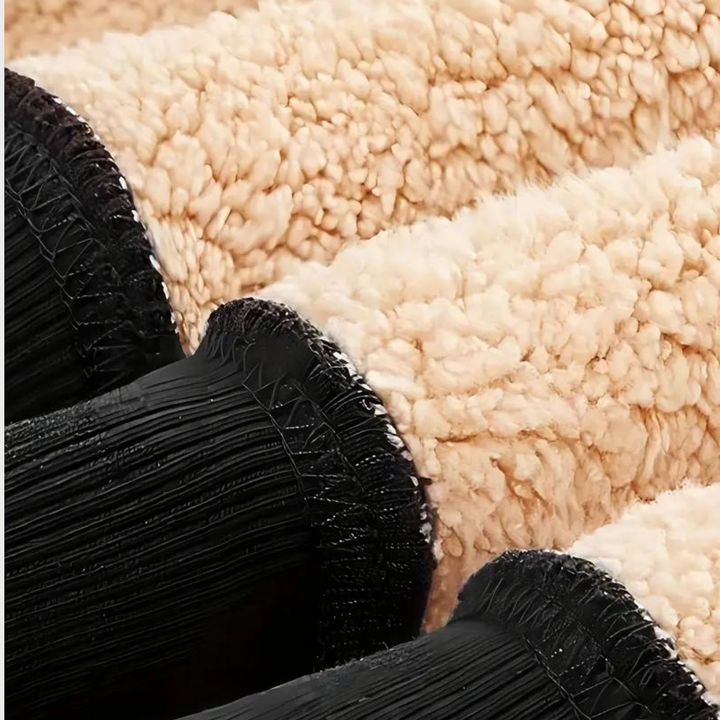 Zachte beige schapenvacht stof met zwarte elastische manchetten, ideaal voor winterkleding en accessoires. Warme, duurzame textieloptie.