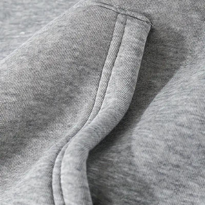 Grijze katoenen hoodie detail, close-up van zachte stof en naad. Comfortabele casual kleding, perfect voor dagelijks gebruik en sportieve activiteiten.