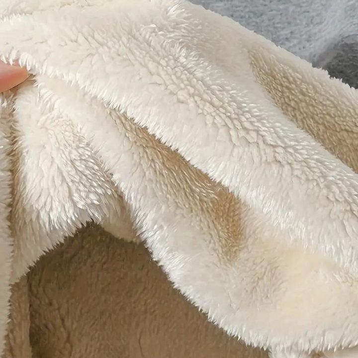 Zachte, crèmekleurige fleece deken, close-up textuur, knus en warm, ideaal voor winterse avonden, huisdecoratie, comfortabele woonaccessoires.