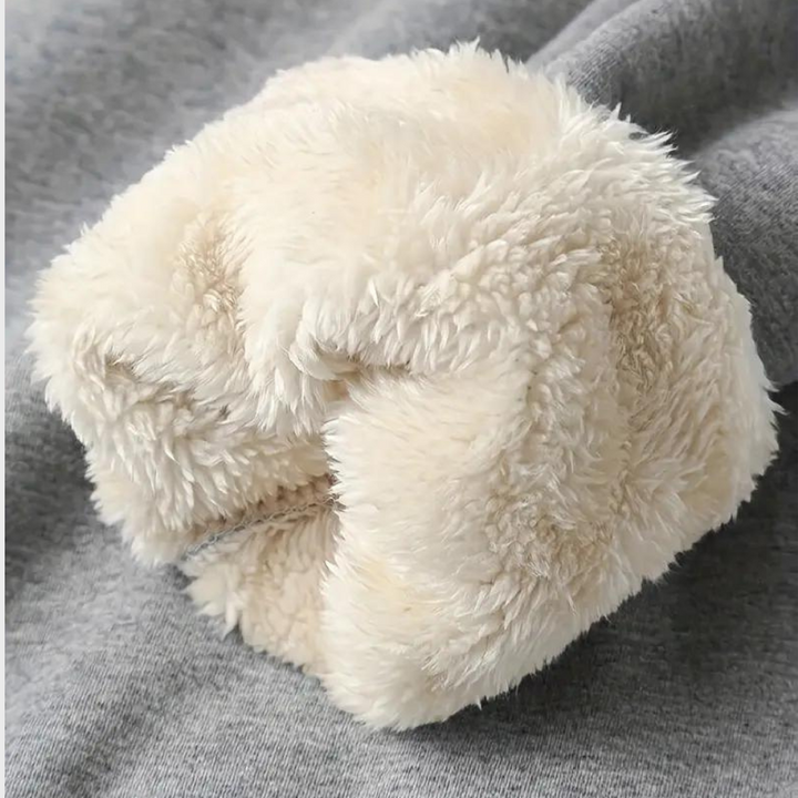 Pluizige, crèmekleurige faux fur scrunchie op grijze achtergrond, modieuze haaraccessoire, trendy en zacht, perfect voor dagelijks gebruik.