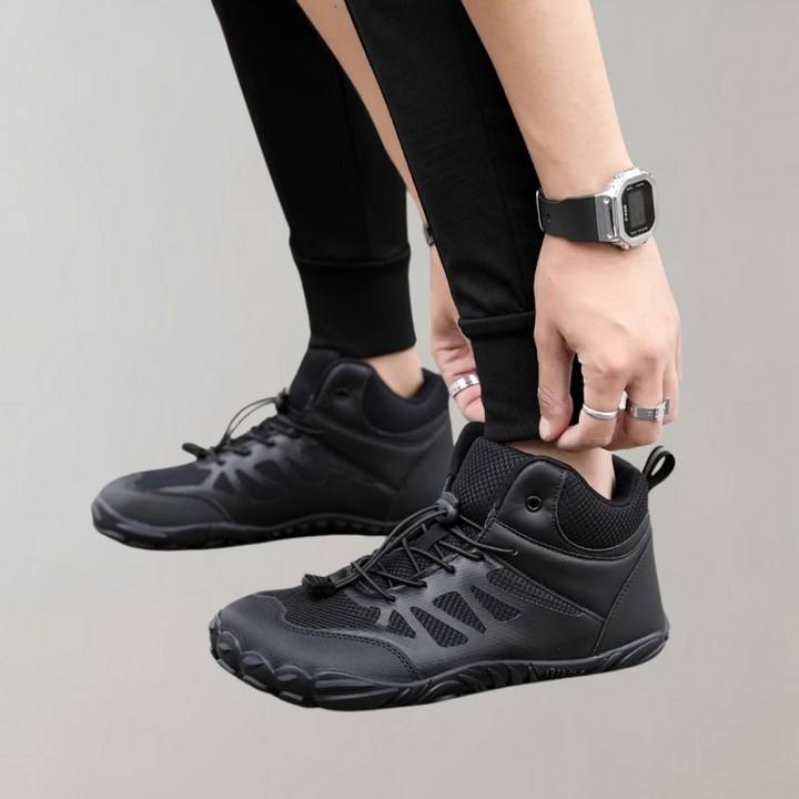 Zwarte hoge sneakers met veters, gedragen door persoon in zwarte broek. Moderne sportieve schoenen, ideaal voor dagelijks gebruik en casual outfits.