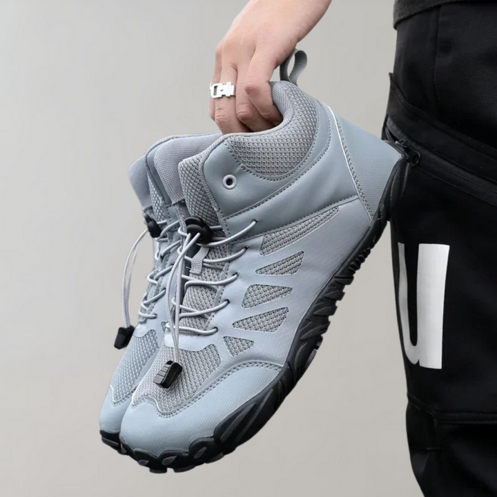 Grijze wandelschoenen met ademend mesh, stevige rubberen zool en vetersluiting. Ideaal voor outdoor activiteiten en avontuurlijke wandeltochten.