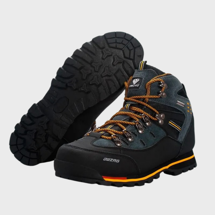 Zwarte en grijze wandelschoenen met oranje veters en stevige rubberen zolen, ideaal voor outdoor avonturen en bergwandelingen.
