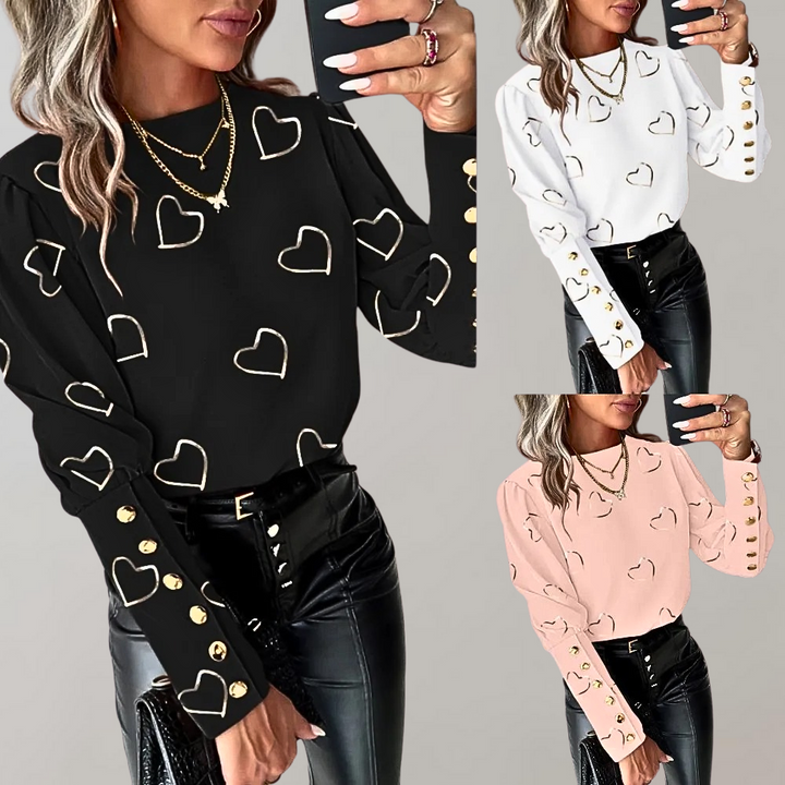 Vrouw draagt zwarte blouse met gouden hartjes en knopen, gecombineerd met zwarte leren broek. Modieuze dameskleding, trendy outfit, stijlvolle look.