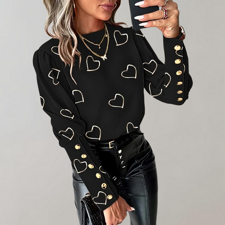Zwarte damesblouse met gouden hartjesprint en knopen, lange mouwen, modieuze uitstraling. Perfect voor casual en chique gelegenheden.