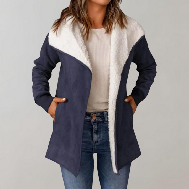Donkerblauwe damesjas met witte fleece voering, lange mouwen en open voorkant. Modieuze winterjas, ideaal voor casual en warme outfits.