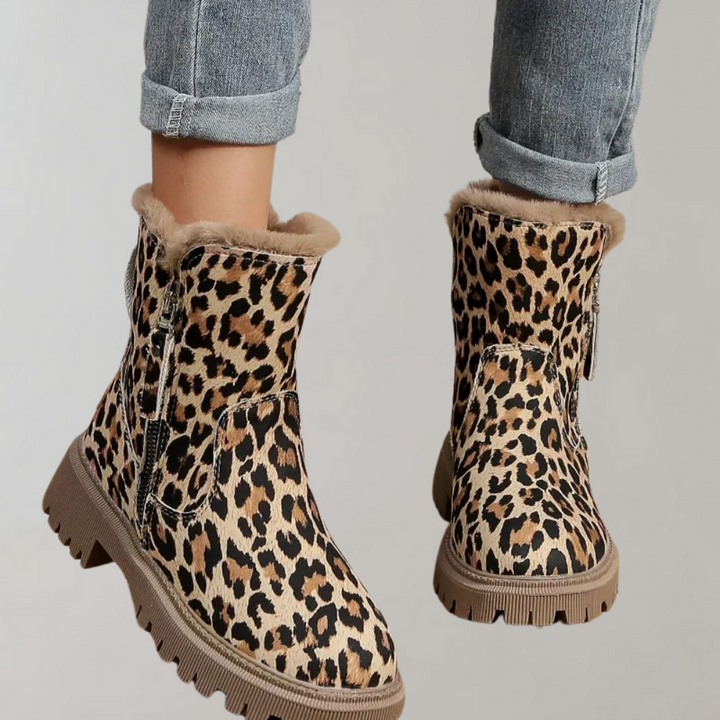 Enkellaarsjes met luipaardprint, warme voering en stevige zool, perfect voor wintermode. Trendy dameslaarzen met rits en opgerolde spijkerbroek.