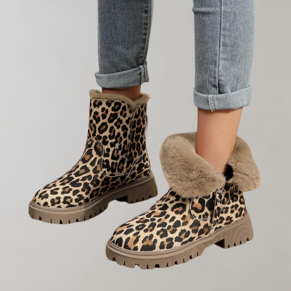 Luipaardprint enkellaarsjes met bontvoering, stevige zool en opgerolde jeans. Modieuze dameslaarzen, trendy wintermode, comfortabele schoenen.