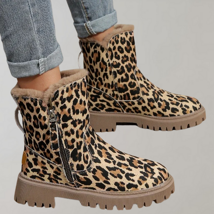 Luipaardprint enkellaarsjes met ritssluiting en warme voering, gedragen met opgerolde jeans. Modieuze dameslaarzen voor herfst en winter.