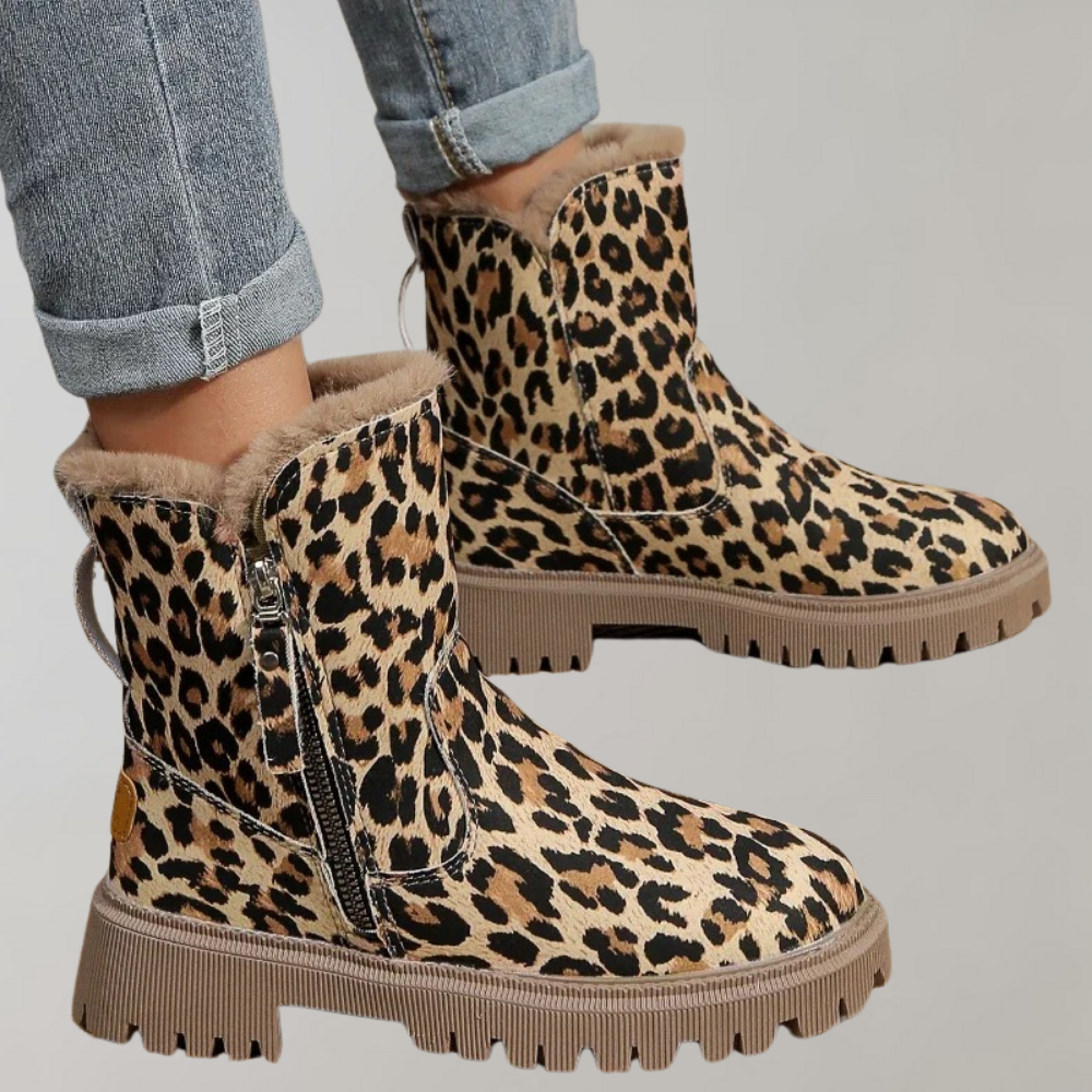 Luipaardprint enkellaarsjes met ritssluiting en dikke zool, gedragen met opgerolde jeans. Modieuze dameslaarzen, trendy herfst- en wintermode.