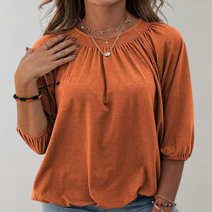 Oranje damesblouse met driekwart mouwen, ronde hals en plooidetails. Modieuze top, ideaal voor casual en zakelijke outfits.