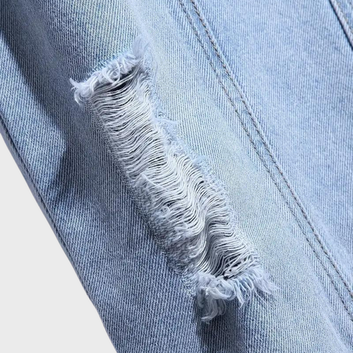 Gescheurde lichtblauwe spijkerbroek met rafelige details, trendy denim mode, close-up textuur, casual kledingstijl, duurzame jeansstof.