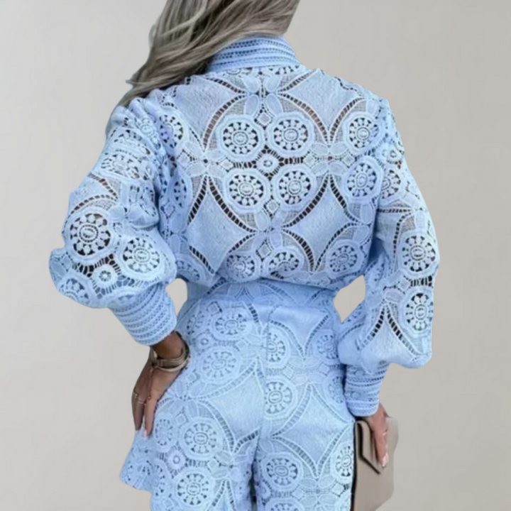 Vrouw in lichtblauw kanten pak met cirkelpatroon, lange mouwen en hoge taille. Modieuze dameskleding, elegant en stijlvol design.