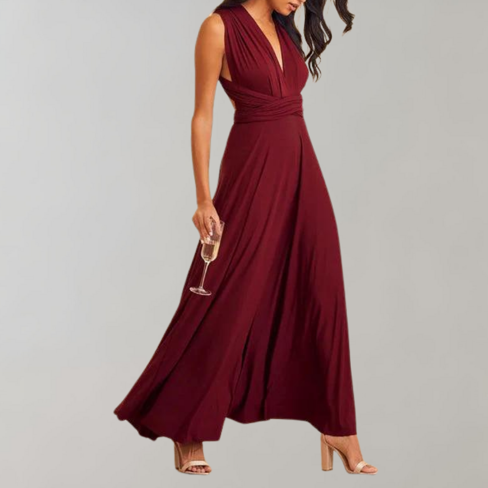 Bordeauxrode avondjurk met diepe V-hals en geplooide taille, gedragen door vrouw met champagneglas. Perfect voor elegante feesten en bruiloften.