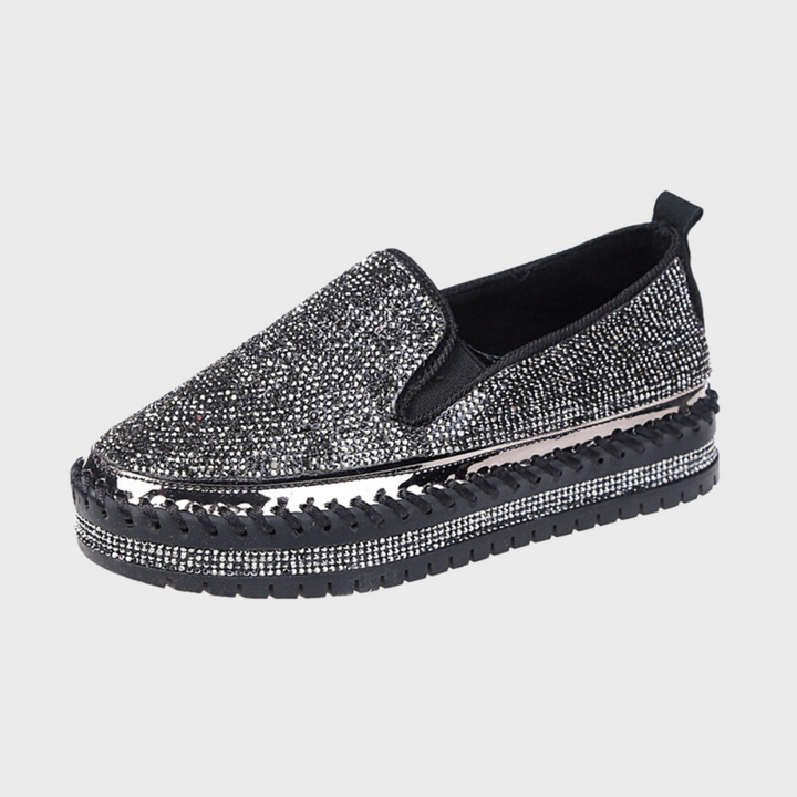Zwarte damesschoen met glinsterende strass-steentjes, dikke zool en slip-on ontwerp. Perfect voor feestelijke gelegenheden en modieuze outfits.