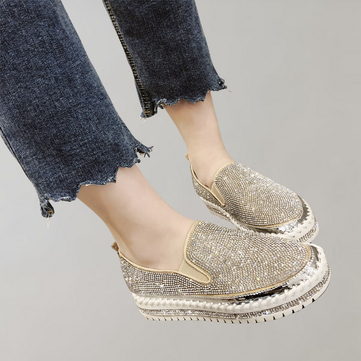 Glinsterende gouden damessneakers met strass, plateauzool en denim broek. Modieuze schoenen, casual stijl, comfortabele pasvorm.