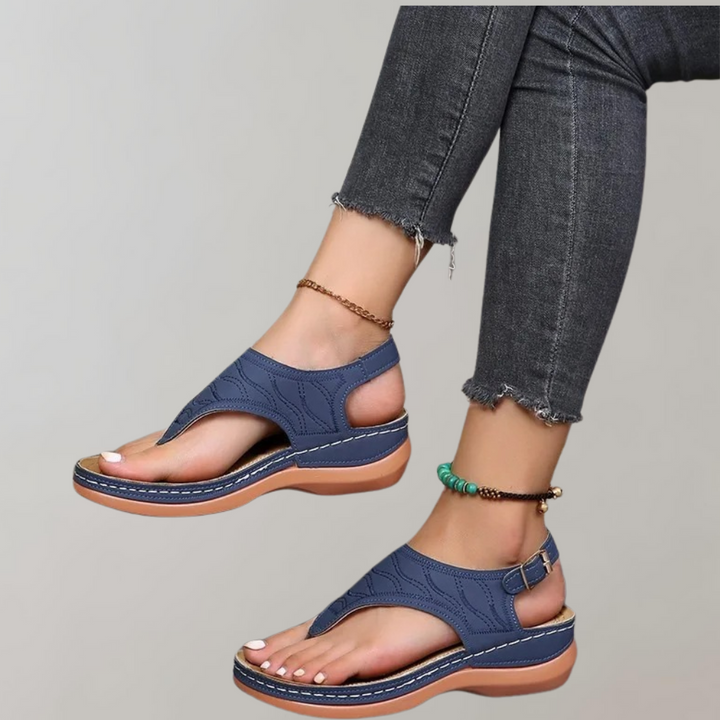 Donkerblauwe sandalen met sleehak, open teen en verstelbare band, gedragen met grijze jeans. Comfortabele zomerschoenen voor dames.