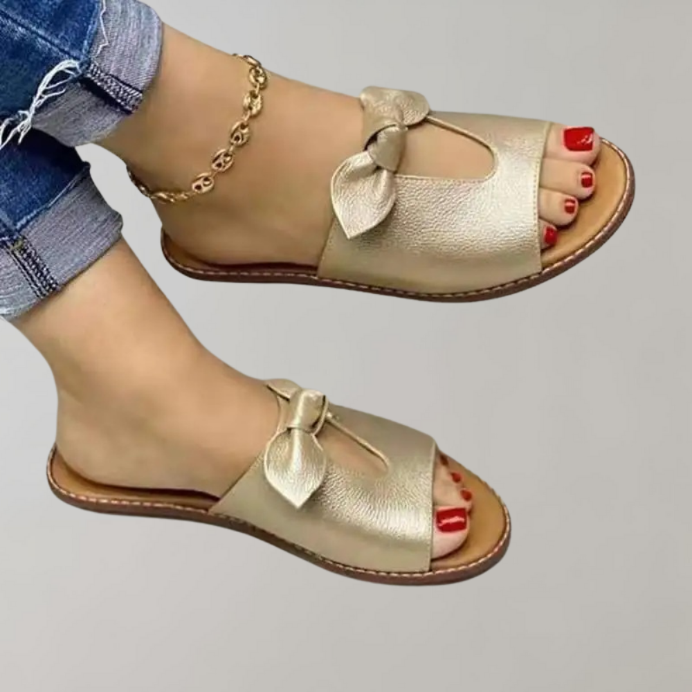 Gouden dames sandalen met strik, open teen en platte zool. Perfect voor casual zomeroutfits. Comfortabele en stijlvolle schoenen.