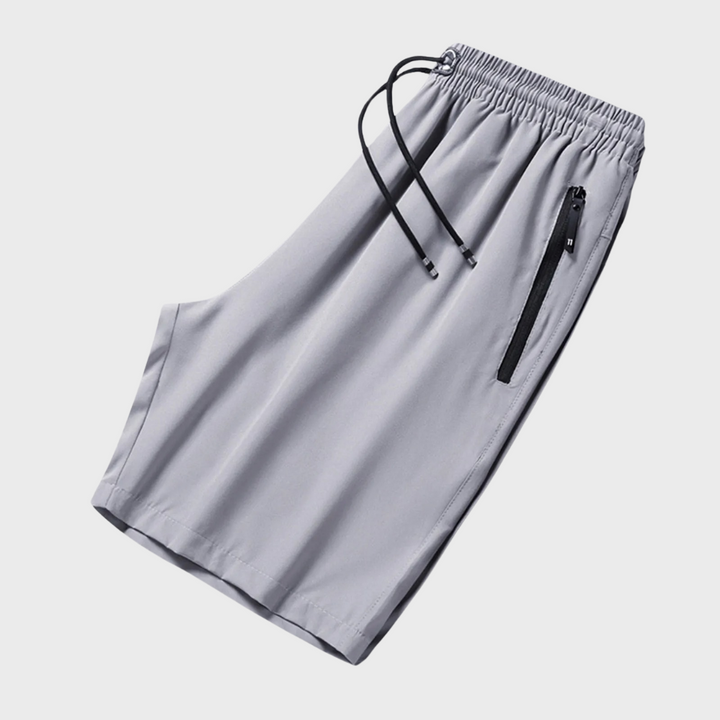Lichtgrijze sportshort met elastische tailleband, trekkoord en ritszak. Ideaal voor heren, zomeractiviteiten en casual sportkleding.
