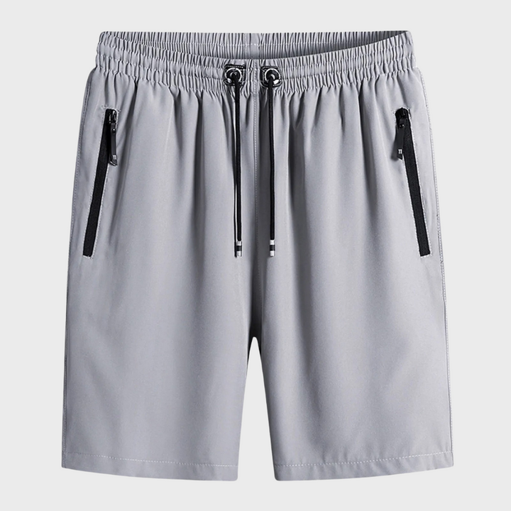 Lichtgrijze sportshorts met elastische tailleband, trekkoord en zwarte ritszakken. Ideaal voor heren, casual en sportieve outfits.