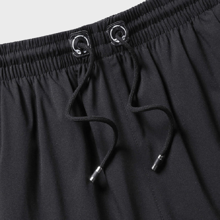 Zwarte sportshorts met elastische tailleband en trekkoord, ideaal voor fitness en hardlopen. Comfortabele en ademende stof voor actieve prestaties.
