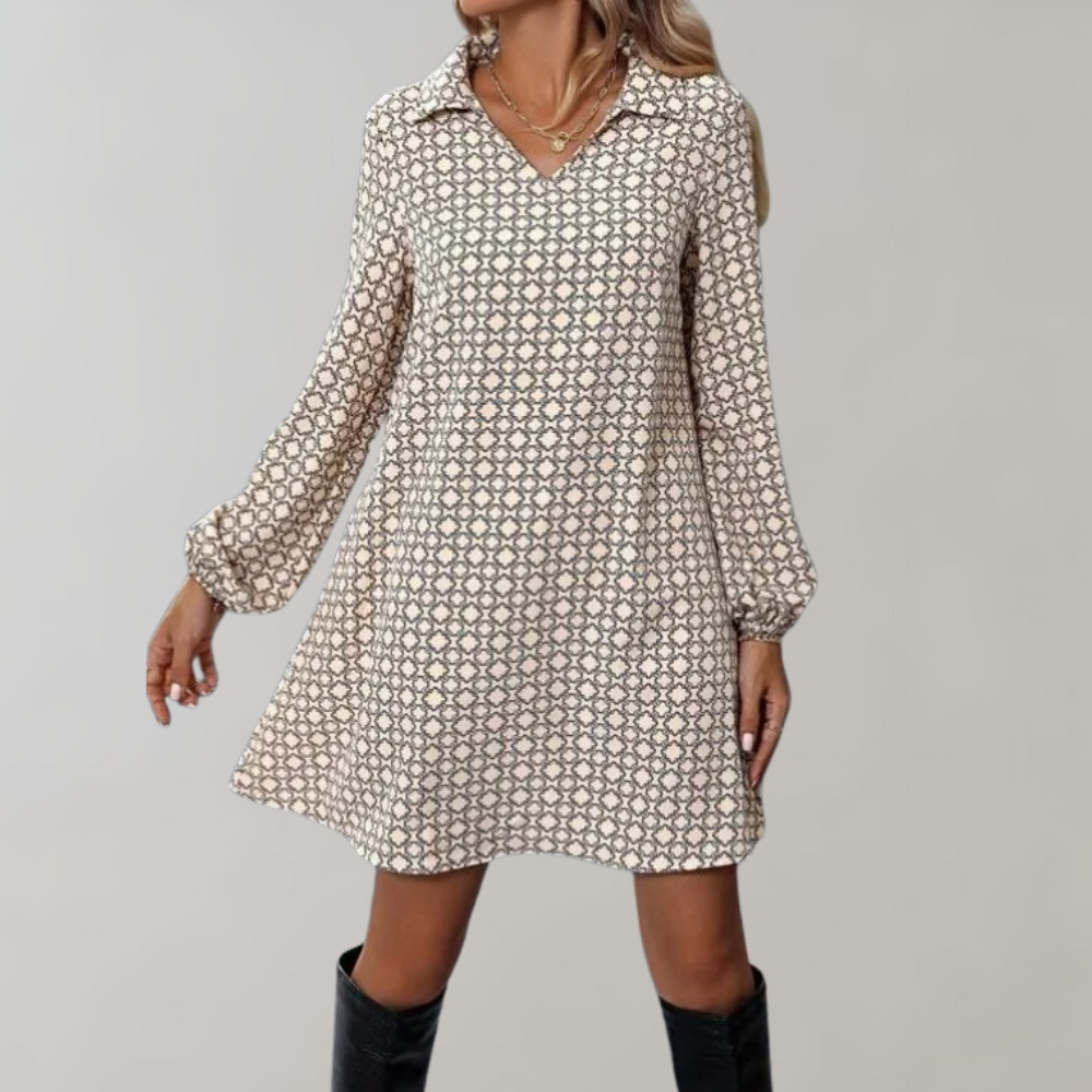 Vrouw in beige jurk met geometrisch patroon, lange mouwen en kraag, gecombineerd met zwarte laarzen. Modieuze dameskleding, herfststijl.