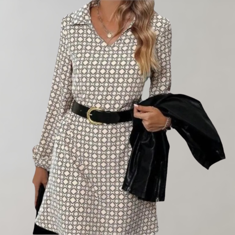 Vrouw in elegante jurk met geometrisch patroon, zwarte riem en jas. Modieuze dameskleding, herfststijl, trendy outfit voor dagelijks gebruik.
