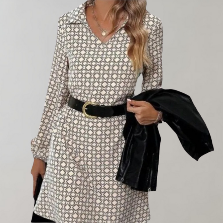 Vrouw in elegante jurk met geometrisch patroon, zwarte riem en jas. Modieuze dameskleding, herfststijl, trendy outfit voor dagelijks gebruik.