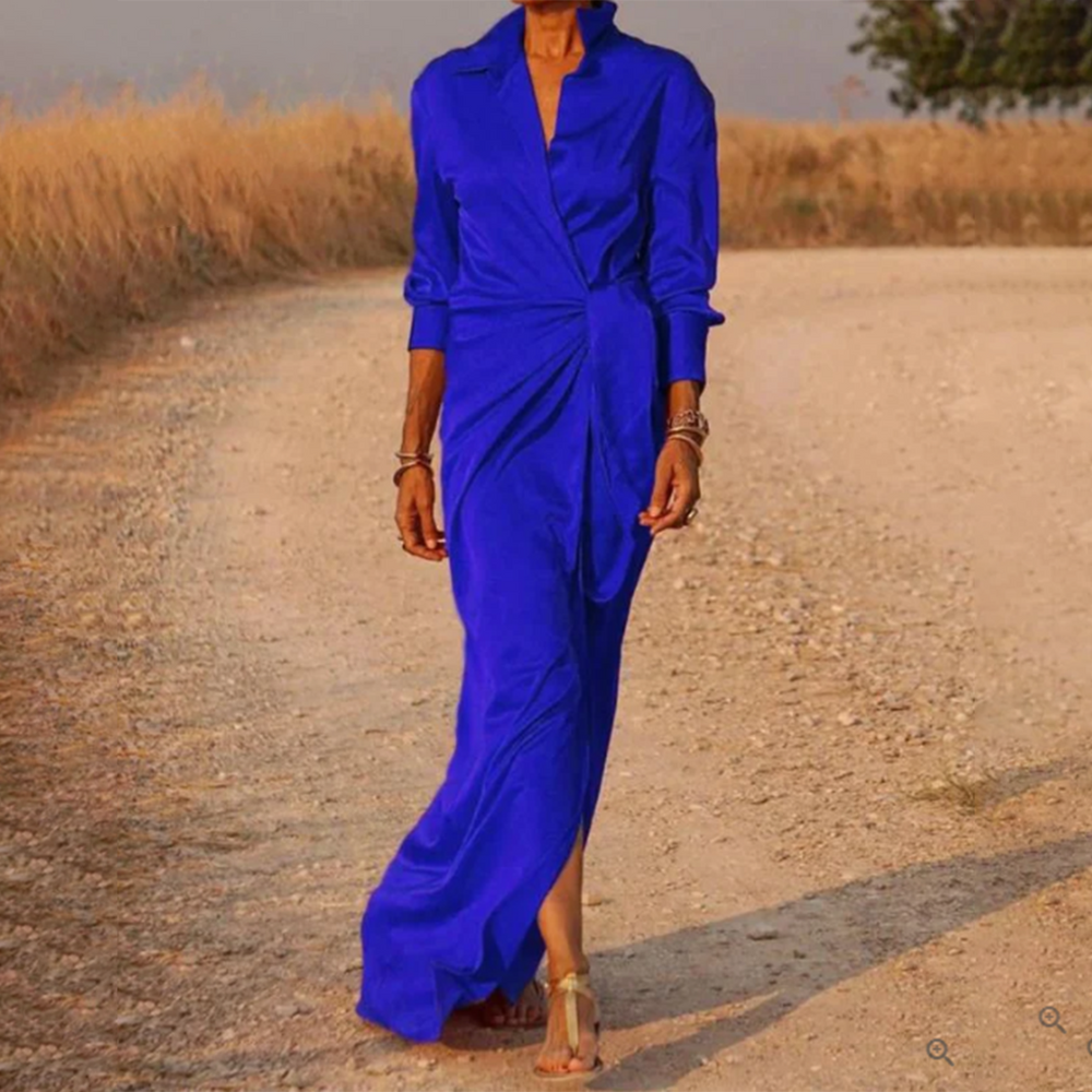 Vrouw in felblauwe lentejurk op landweg, elegante stijl, modetrend, lange mouwen, zomerkleding, casual chique, outdoor fotoshoot.