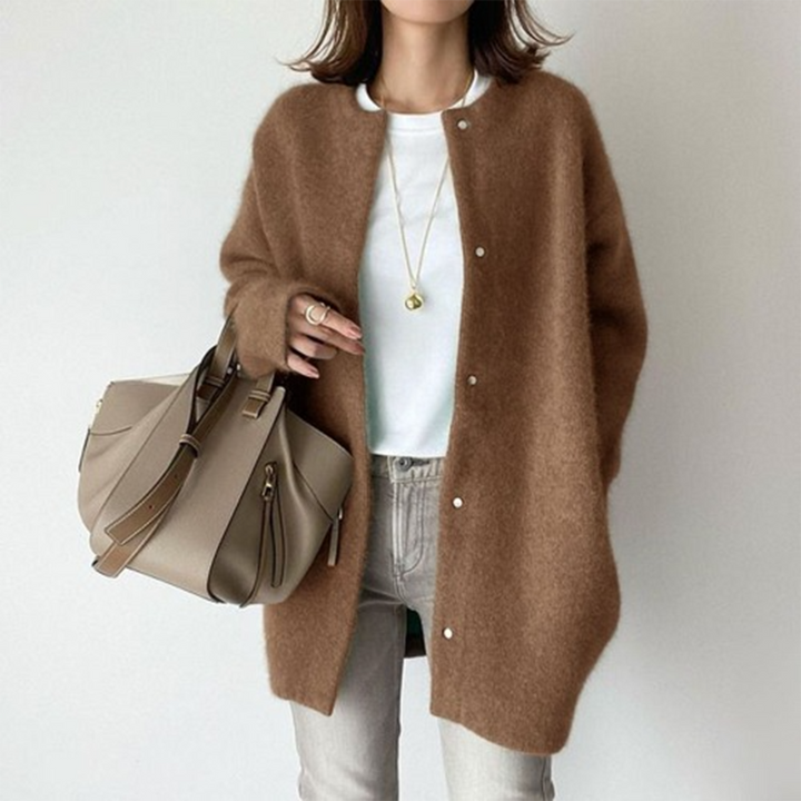 Vrouw in bruine wollen jas met knopen, witte top en beige handtas. Modieuze herfstoutfit, casual stijl, damesmode, trendy accessoires.