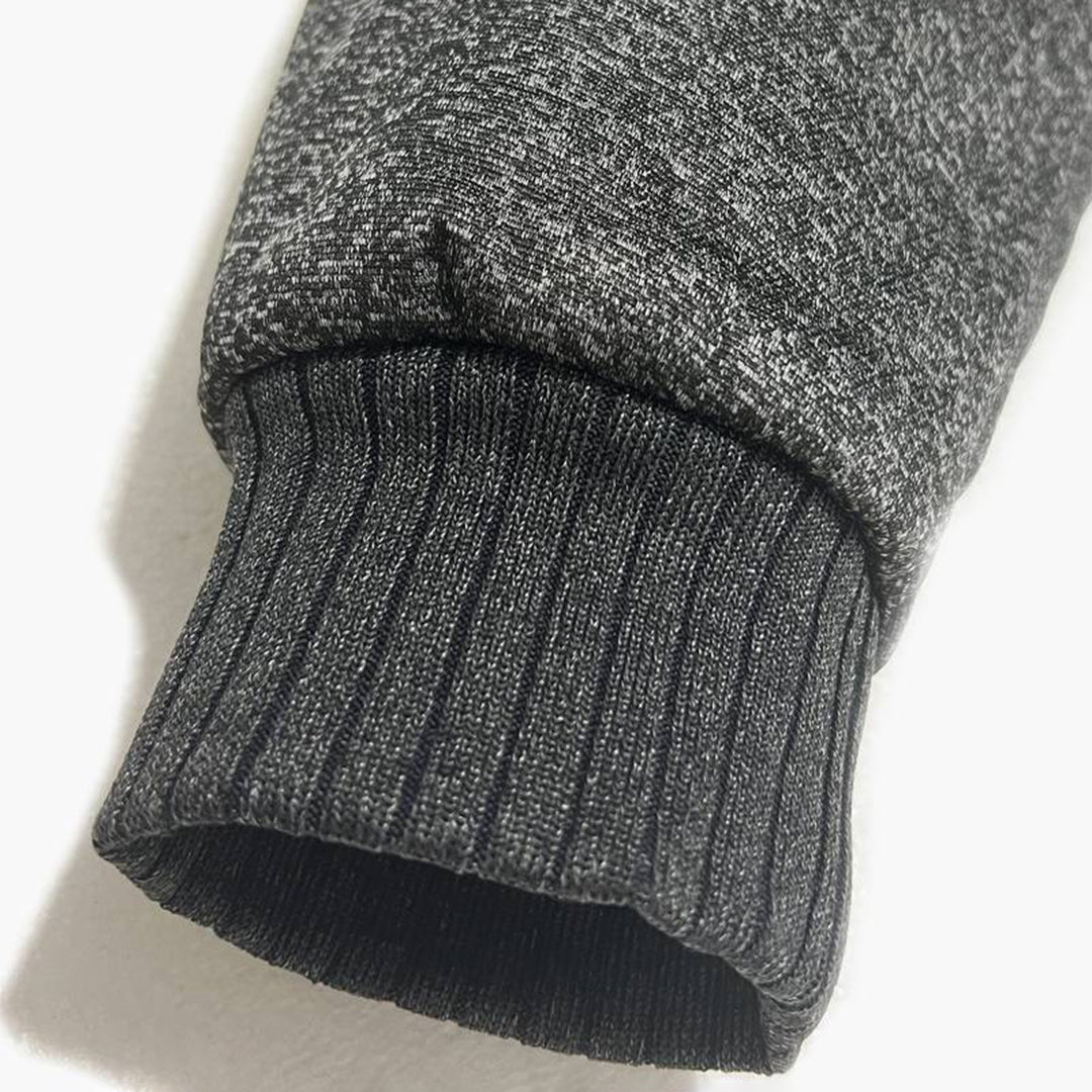 Grijze gebreide mouw van een trui, close-up. Hoogwaardige stof, comfortabel en stijlvol. Perfect voor herfst- en wintermode.