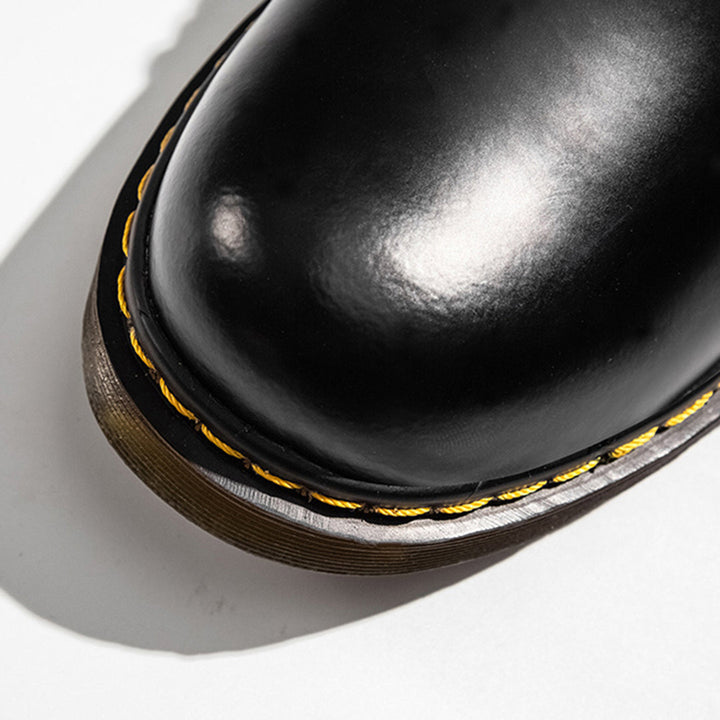 Zwarte leren schoen met gele stiksels, close-up van de neus. Hoogwaardige herenschoen, duurzaam design, modieuze uitstraling.