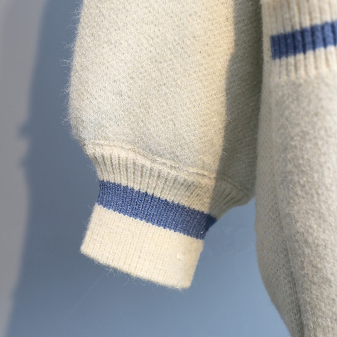 Crèmekleurige wollen trui met blauwe strepen, close-up van mouwboord. Hoogwaardige wintermode, warme gebreide kleding, stijlvolle herenkleding.