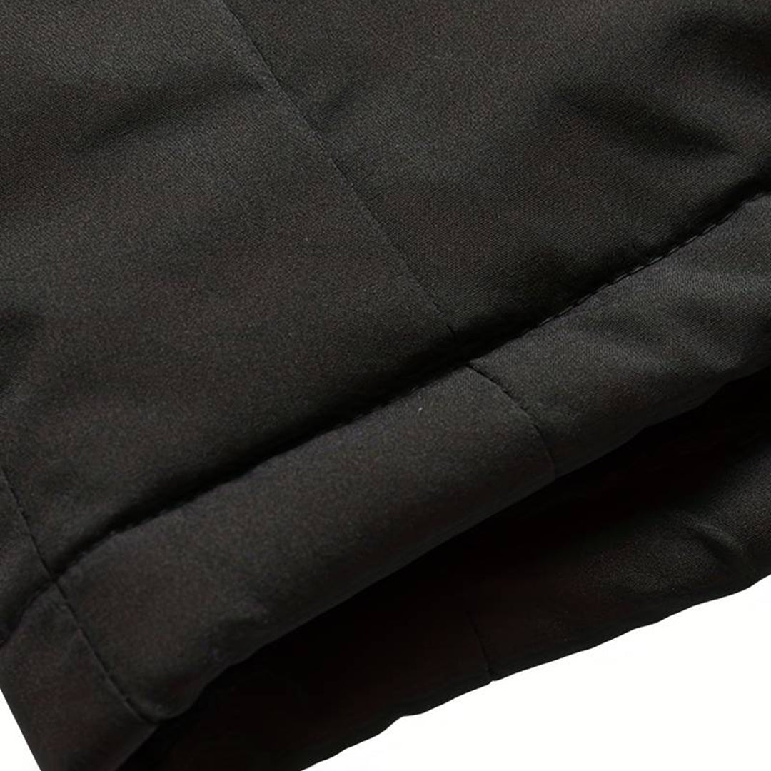Zwarte gewatteerde jas, close-up van de mouw. Hoogwaardige winterjas, warme isolatie, modieus design. Perfect voor koude weersomstandigheden.