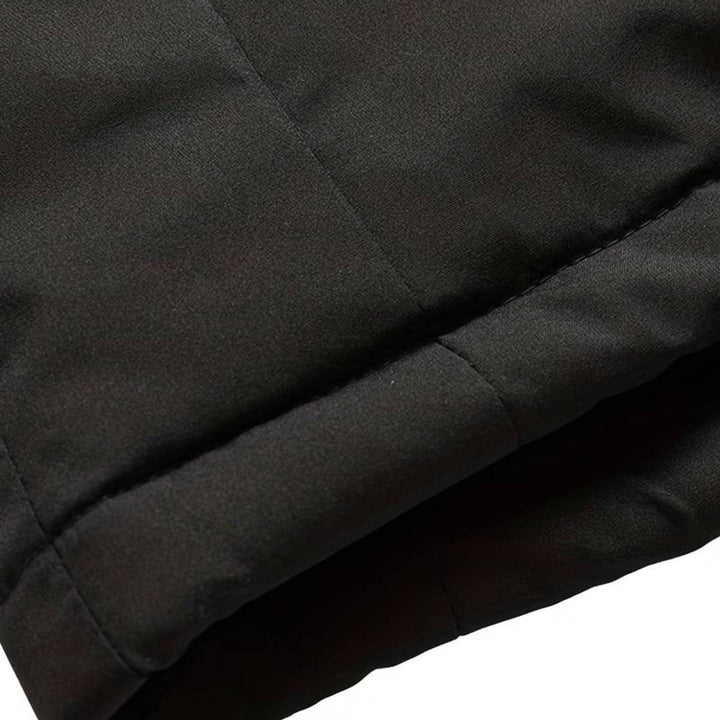 Zwarte gewatteerde jas, close-up van de mouw. Hoogwaardige winterjas, warme isolatie, modieus design. Perfect voor koude weersomstandigheden.