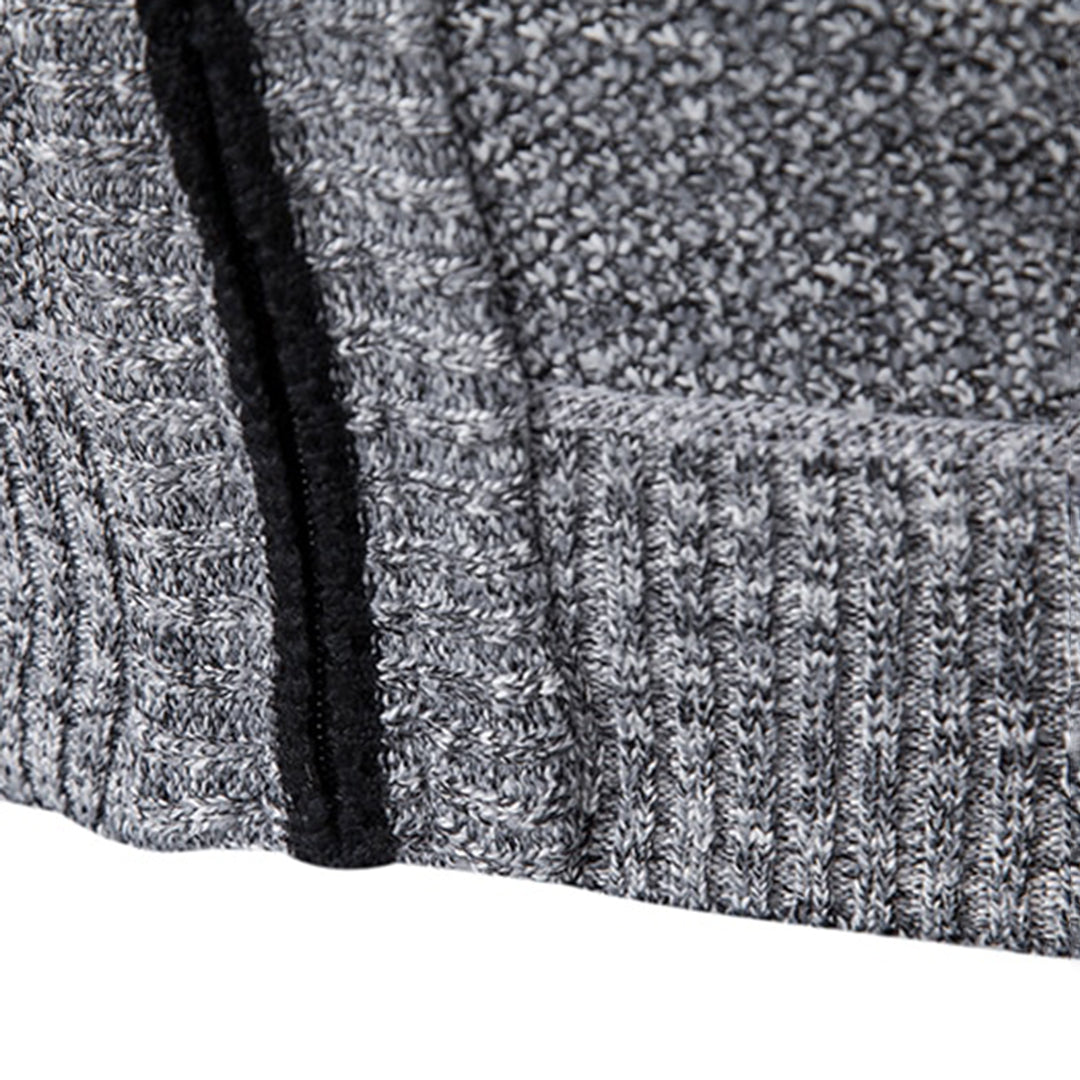 Grijze gebreide trui close-up, textuur en patroon zichtbaar, met zwarte ritssluiting. Comfortabele wintermode, warme kleding, stijlvolle herenkleding.