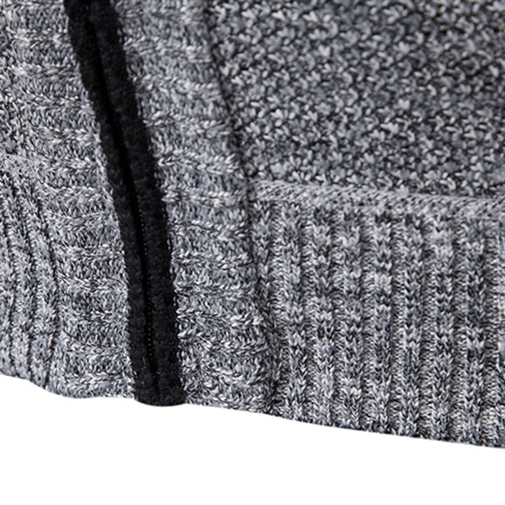 Grijze gebreide trui close-up, textuur en patroon zichtbaar, met zwarte ritssluiting. Comfortabele wintermode, warme kleding, stijlvolle herenkleding.